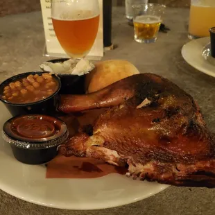 Smoked chicken with baked beans, mashed potatoes, and yeast roll with a delicious Hopslam
