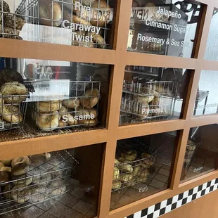 a variety of bagels in a display case