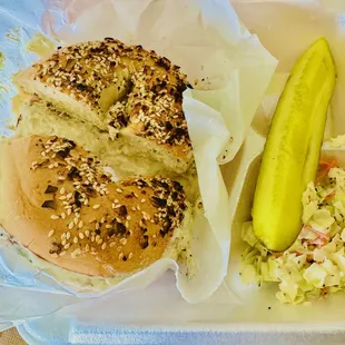 whitefish salad on an everything bagel with slaw and a pickle