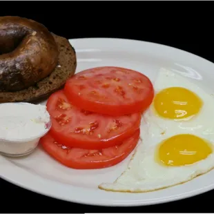 fried eggs, tomatoes, and a bagel