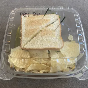 Egg salad sandwich on toasted white bread served with potato chips &amp; pickle spear. Really nice presentation for delivery order.
