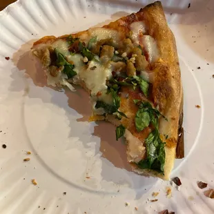 Slice of pie with spinach, garlic, and ground beef.