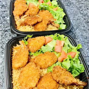 Jumbo fried shrimp over rice and salad.