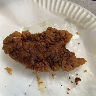 a piece of fried chicken on a paper plate