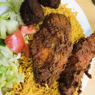 Fish over rice with a side of falafel and salad