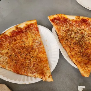 two slices of pizza on paper plates