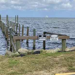 a wooden pier with a sign pointing to the right