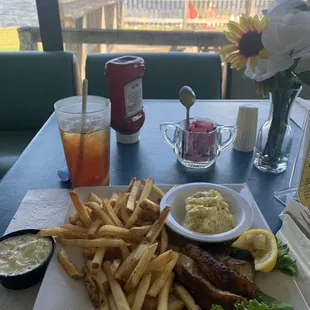 Grilled salmon, potato salad, fries, and fresh iced tea.
