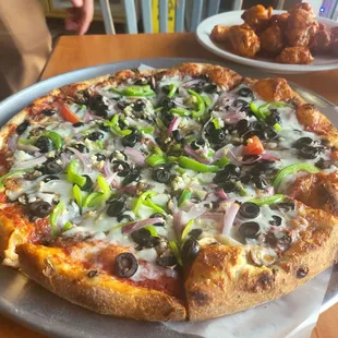 2 lonely end pieces of tomato on a veggie pizza
