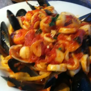 Sea dish mussels clams scallops and calamari over pasta     Seafood fra diavolo