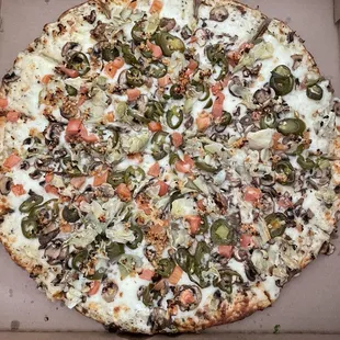 Extra large veggie pizza with white sauce and all the toppings including jalapeños.