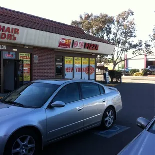 a silver car parked in front of a restaurant