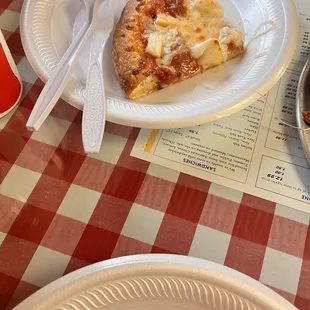 a slice of pizza on a paper plate