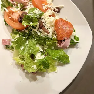 Antipasto Salad. Pepperoni, tomato wedges, olives, salami, ham, grated mozzarella cheese. Served with Italian dressing.