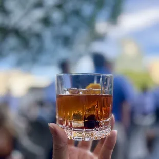 a hand holding a glass of whiskey