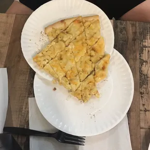 a slice of pizza on a paper plate