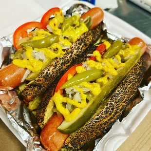 two hotdogs with peppers and onions