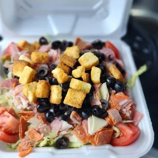 a salad in a styrofoam container