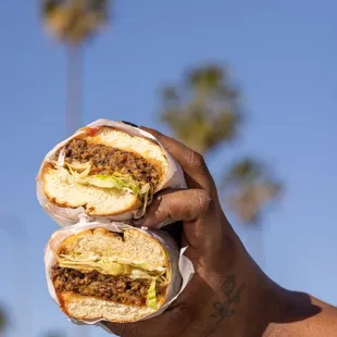 a hand holding a sandwich