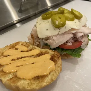 Spicy Turkey on a Toasted Brioche Bun: turkey, pepperjack, sriracha mayo, romaine, tomatoes, pickled jalapeños