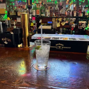 a glass of water with a lime slice in it