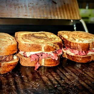 three sandwiches on a grill