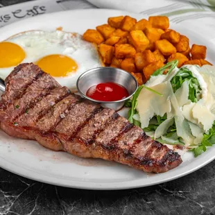 STEAK &amp; EGGS: Center Cut New York Steak, Two Eggs any Style, House Potatoes, Baby Arugula. Served with your Choice of Toast