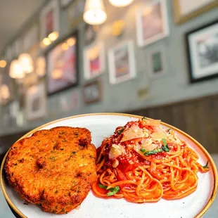 a plate of spaghetti and a chicken cutlet