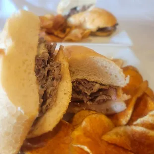 Sliced Ribeye steak sandwich with homemade chips.