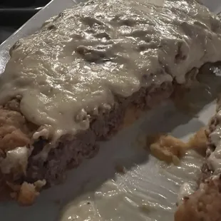 Chicken Fried Sirloin Steak lifted with mashed potatoes cut in half.