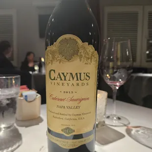 a bottle of caymus wine on a table