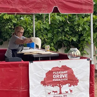 a woman sitting at a table under a red tent