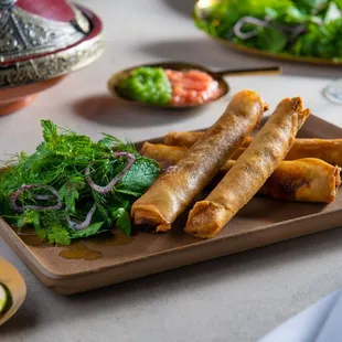 a plate of spring rolls and a salad