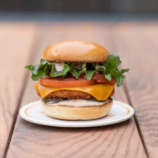 a hamburger with cheese, tomato, and lettuce