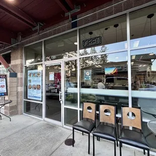 the outside of a restaurant with tables and chairs