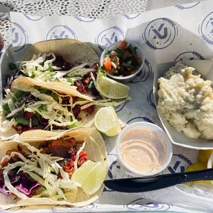 3 brisket taco with a side of potato salad.