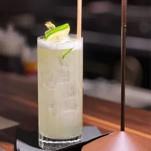 a drink with a lime garnish