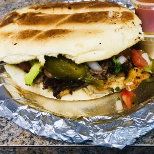 Mexican torta! A delicious grilled sandwich made with fresh ingredients meat melted cheese abocado picó and beans and slice jalapeño