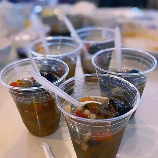 a variety of soups in plastic cups