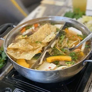 a pot of soup with tortillas