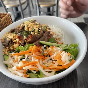 a bowl of noodles with meat and vegetables