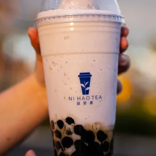 a hand holding a cup of bubble tea