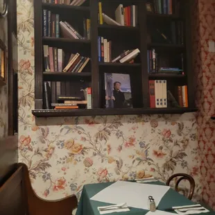 a dining room with a table and bookshelf