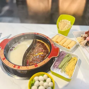 ot pot of soup and a bowl of noodles