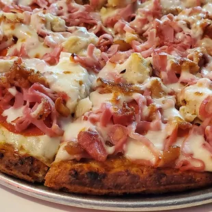 4 Meat pizza with ham, bacon, chicken, and pepperoni and mozz and provolone cheeses.