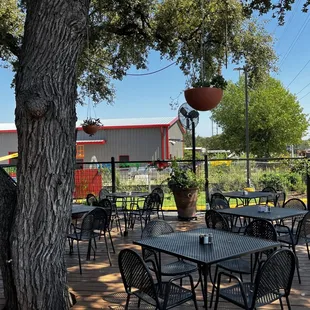 tables and chairs under a tree