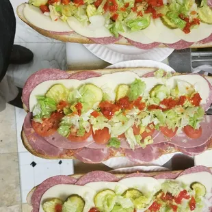 two sub sandwiches with tomatoes and lettuce