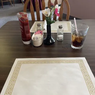 a table with a placemat and a vase of flowers