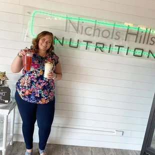 a woman standing in front of a neon sign