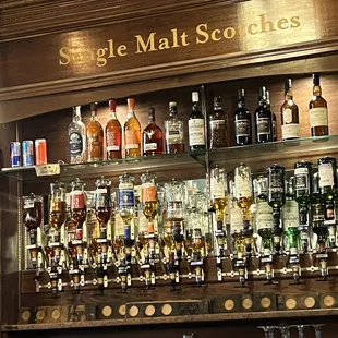 a shelf of liquor bottles and glasses